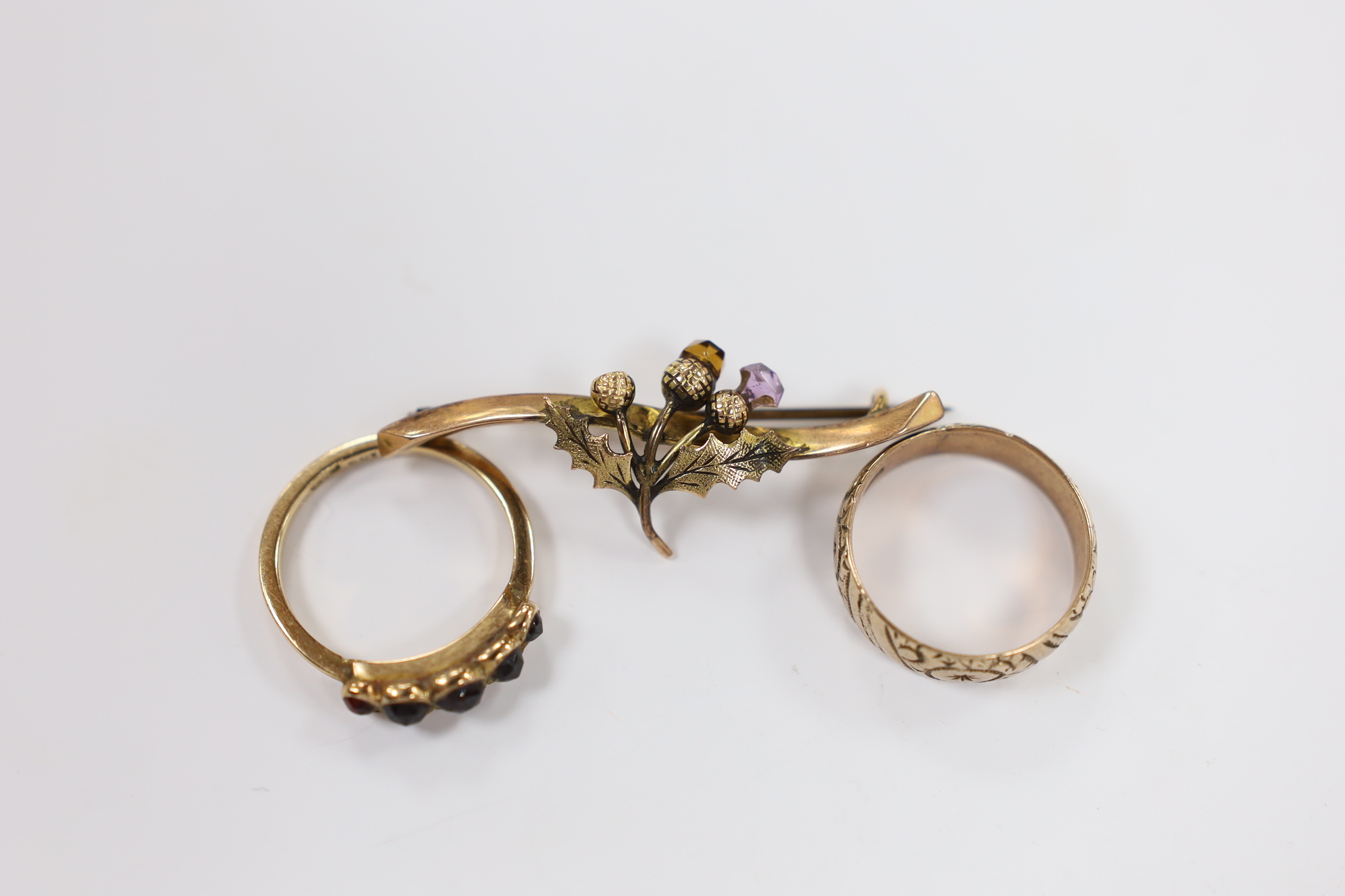 A 9ct and graduated five stone facetted garnet set ring, an engraved 9ct gold band and a 9ct gold and gem set bar brooch (stone missing), gross weight 8.5 grams.
